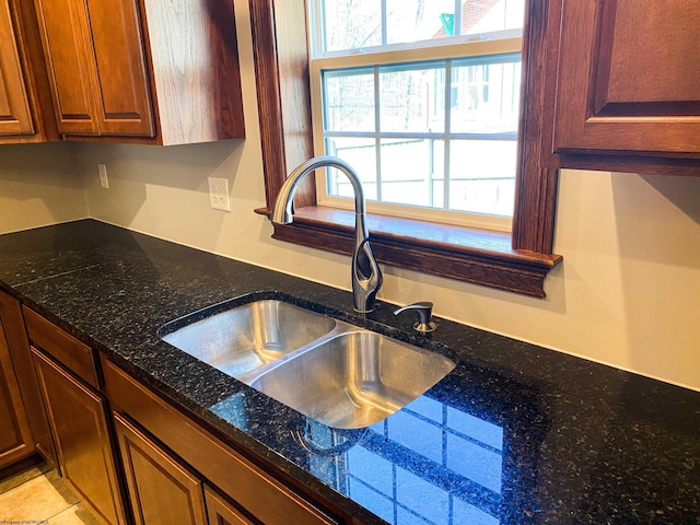 interior details with dark stone counters and a sink