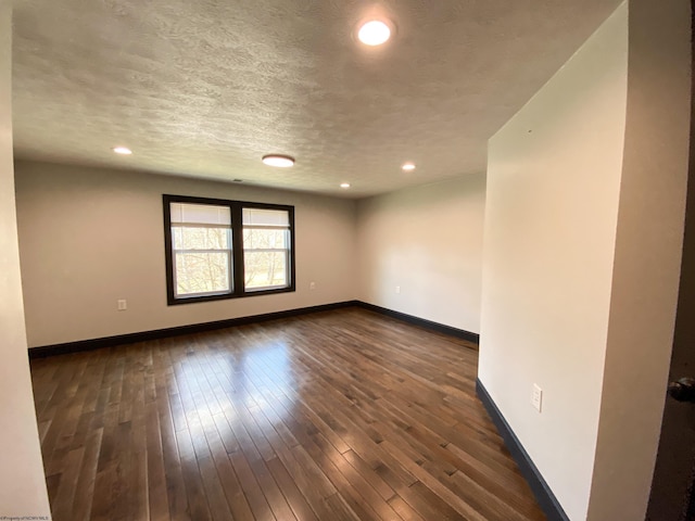 unfurnished room featuring baseboards, a textured ceiling, dark wood-style floors, and recessed lighting