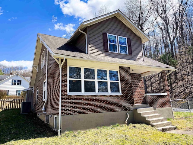 view of front of property featuring brick siding, fence, and a front yard