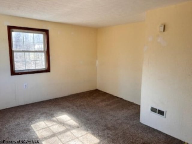 carpeted empty room featuring visible vents