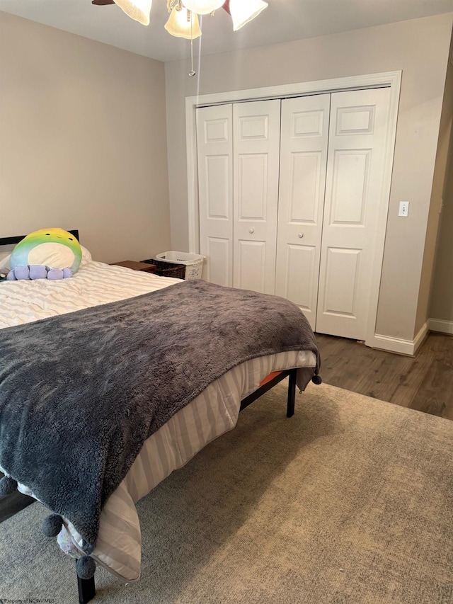 bedroom featuring baseboards, a closet, ceiling fan, and wood finished floors