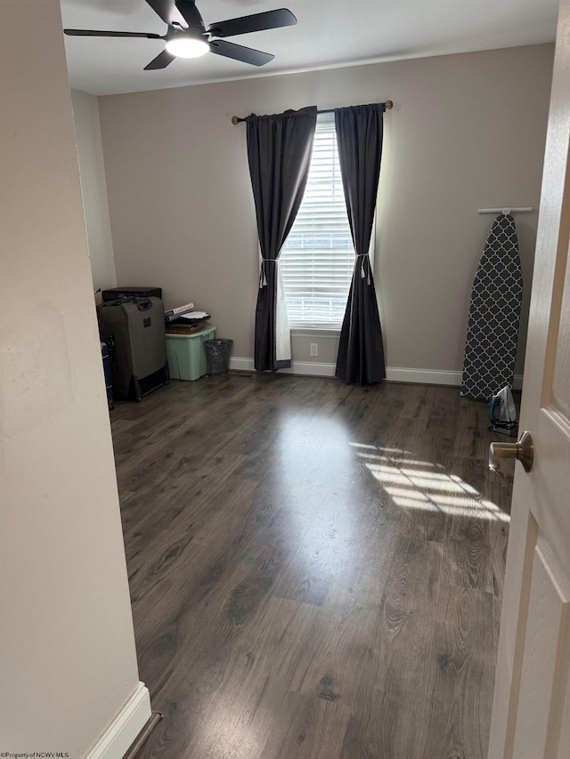 empty room with baseboards, ceiling fan, and wood finished floors