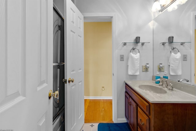 bathroom with baseboards, wood finished floors, and vanity