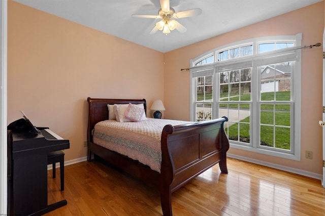 bedroom with baseboards, light wood-type flooring, and ceiling fan