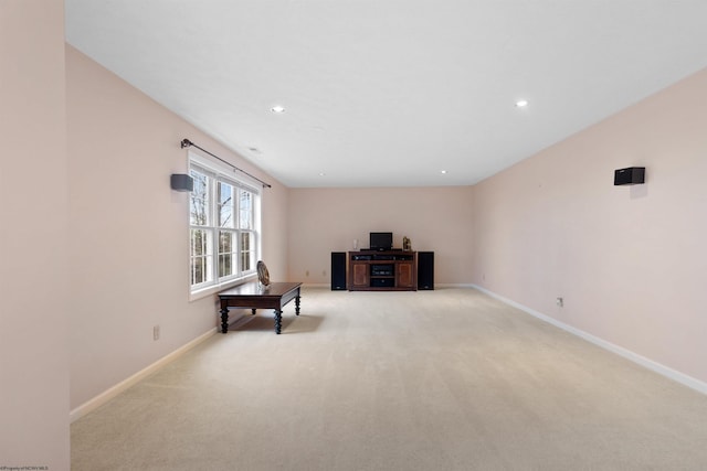 sitting room with baseboards, recessed lighting, and light colored carpet