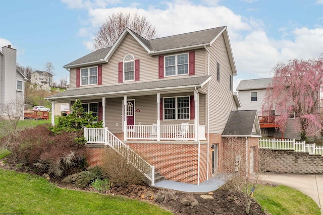 view of front of property featuring fence, stairs, a garage, driveway, and covered porch