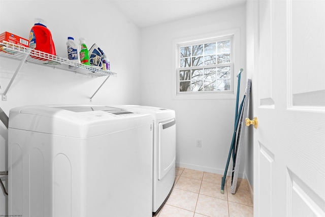 washroom featuring light tile patterned floors, washing machine and dryer, baseboards, and laundry area
