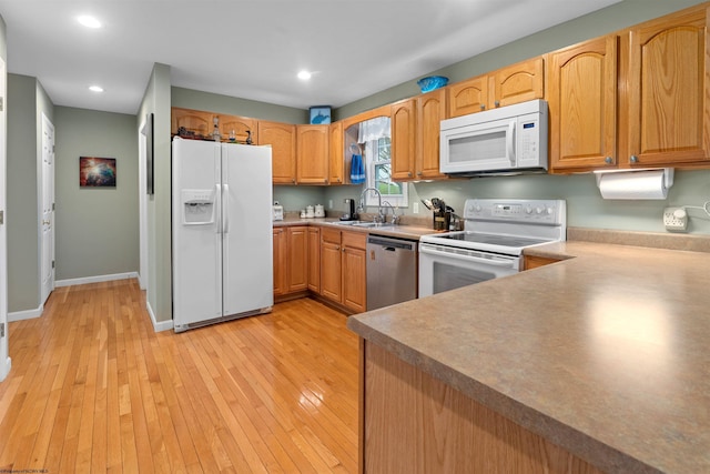 kitchen with recessed lighting, white appliances, baseboards, a sink, and light wood-style floors
