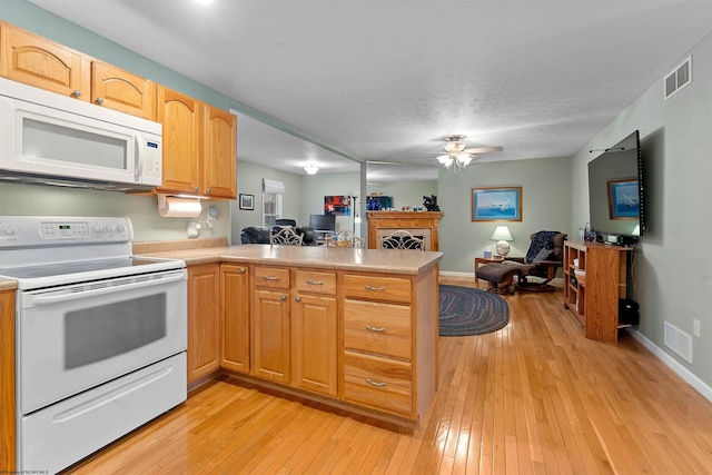 kitchen with open floor plan, visible vents, a peninsula, and white appliances
