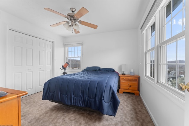 bedroom featuring carpet flooring, a ceiling fan, baseboards, and a closet