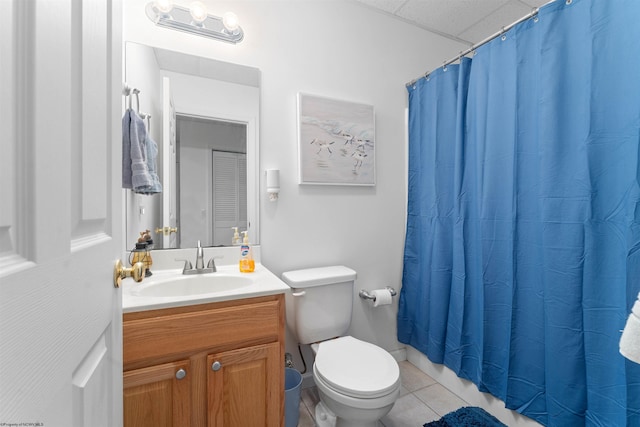 bathroom with toilet, curtained shower, vanity, tile patterned flooring, and a drop ceiling