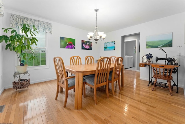 dining area featuring baseboards, light wood-type flooring, visible vents, and an inviting chandelier