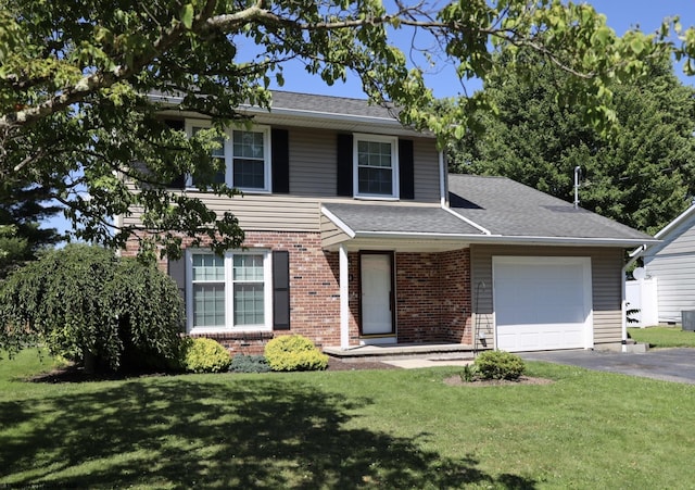 view of front of house featuring roof with shingles, an attached garage, driveway, a front lawn, and brick siding