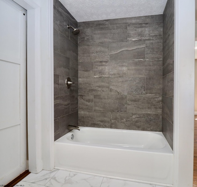 full bathroom featuring marble finish floor, a textured ceiling, and shower / bathtub combination