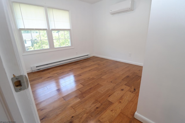 empty room featuring wood-type flooring, a wall unit AC, baseboards, and baseboard heating