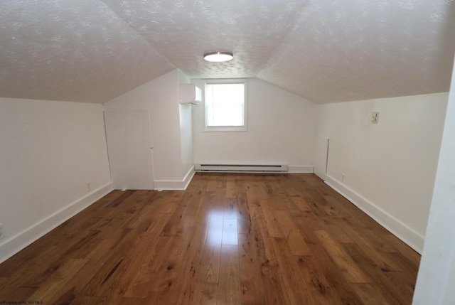 bonus room featuring vaulted ceiling, hardwood / wood-style floors, baseboards, a textured ceiling, and a baseboard radiator