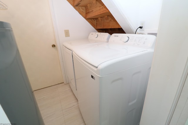 laundry room featuring light tile patterned floors, laundry area, and washer and dryer