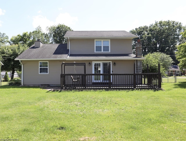 back of property featuring a chimney, fence, a deck, and a yard