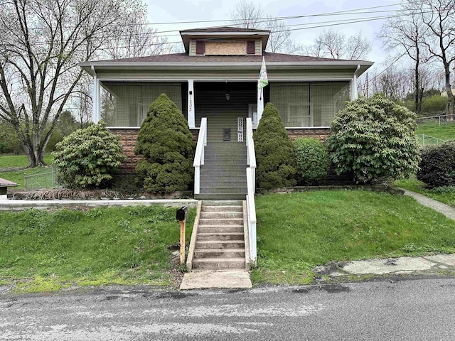 bungalow-style home with a front yard and stairway