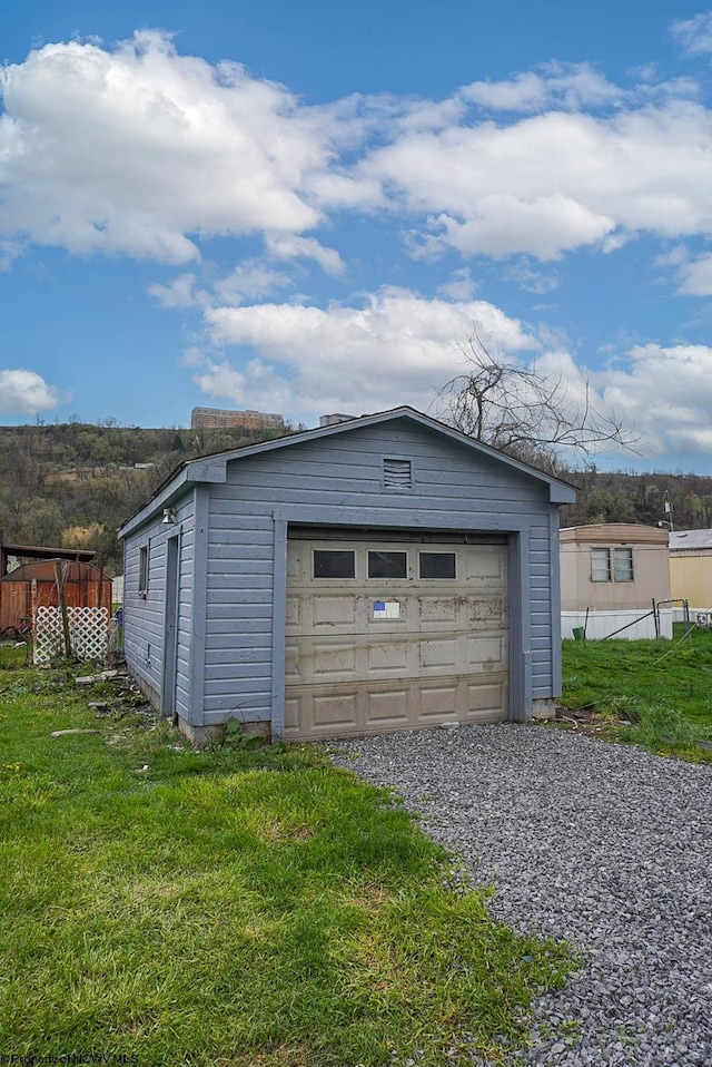 detached garage with fence and driveway