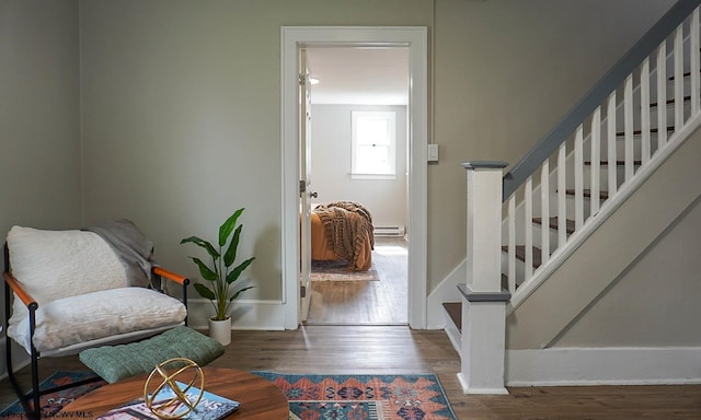 entrance foyer featuring stairway, a baseboard heating unit, baseboards, and wood finished floors