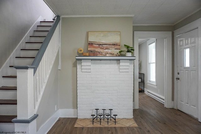 foyer with baseboards, a baseboard heating unit, stairway, crown molding, and wood finished floors