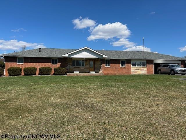 ranch-style house with a front yard, brick siding, and an attached garage