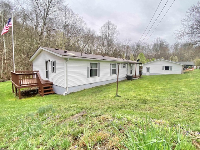 rear view of property with a deck, a lawn, and crawl space