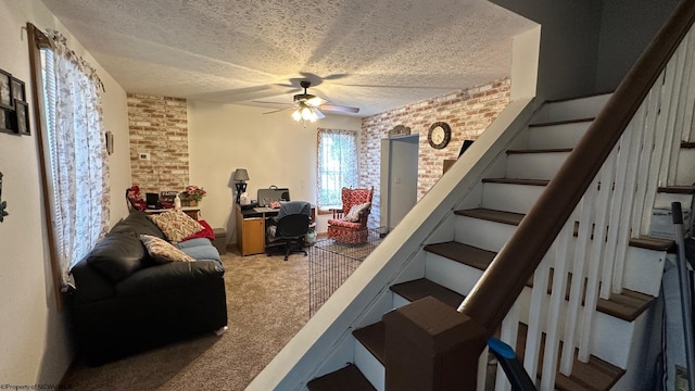 staircase with brick wall, carpet flooring, a textured ceiling, and ceiling fan