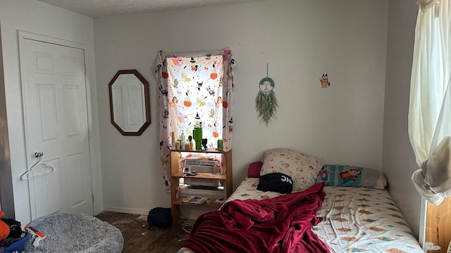 bedroom with a textured ceiling and wood finished floors