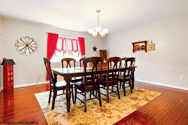 648 Ashberry Dr, Flemington, WV 26347 - dining room featuring wood-type flooring, baseboards, and an inviting chandelier