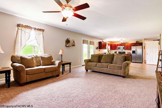 648 Ashberry Dr, Flemington, WV 26347 - living room featuring a healthy amount of sunlight, light colored carpet, ceiling fan, and baseboards