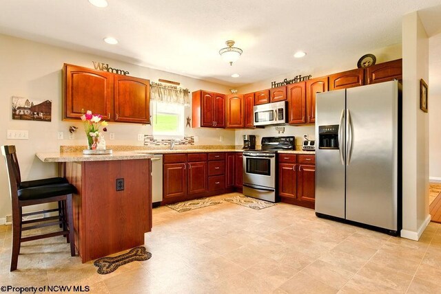 648 Ashberry Dr, Flemington, WV 26347 - kitchen featuring a kitchen breakfast bar, recessed lighting, a peninsula, light countertops, and appliances with stainless steel finishes