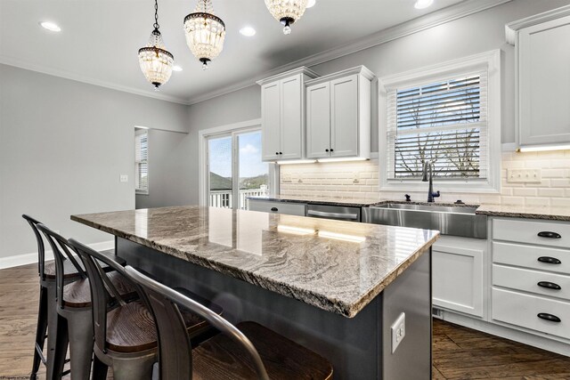 kitchen featuring recessed lighting, a breakfast bar, and a sink