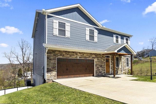 craftsman-style home with a front yard, driveway, stone siding, and an attached garage