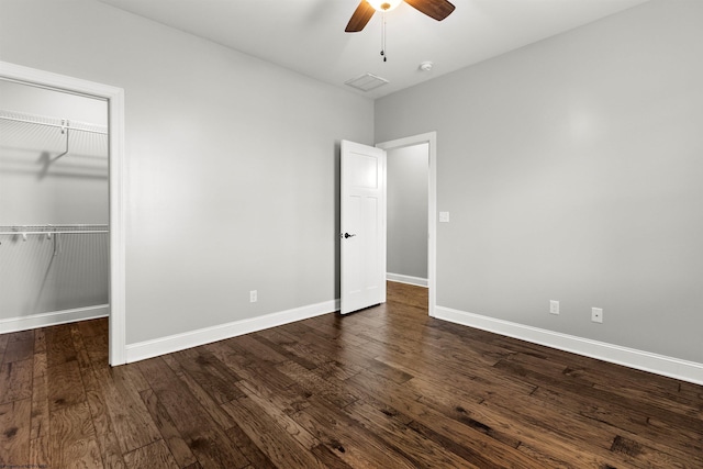 unfurnished bedroom featuring ceiling fan, dark wood-type flooring, a closet, visible vents, and baseboards