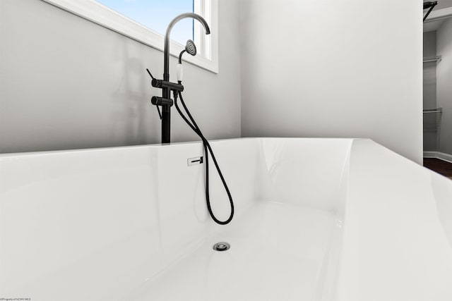 room details featuring a sink and a tub to relax in
