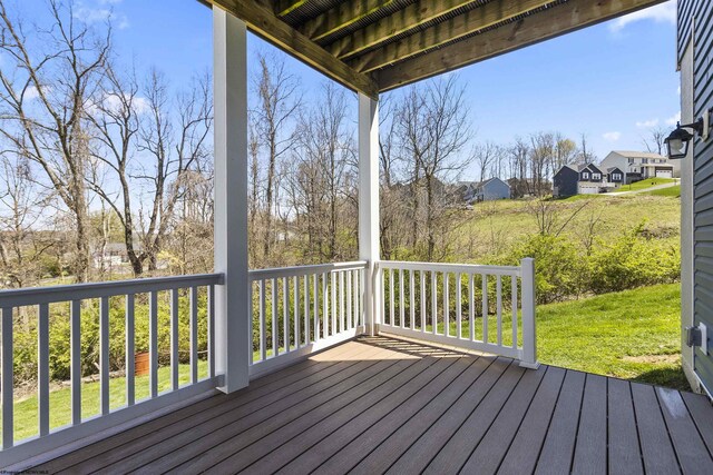 wooden terrace featuring a residential view and a lawn