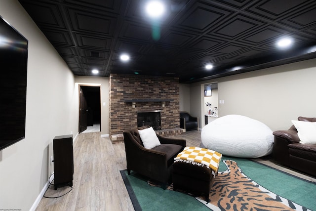 living room featuring recessed lighting, light wood-style floors, an ornate ceiling, baseboards, and a fireplace