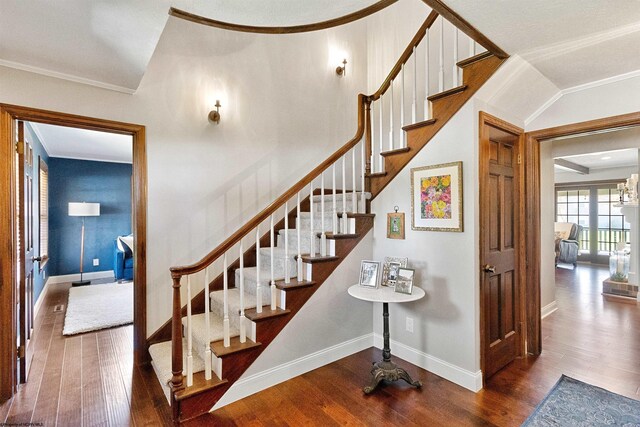 staircase featuring baseboards, ornamental molding, and wood finished floors