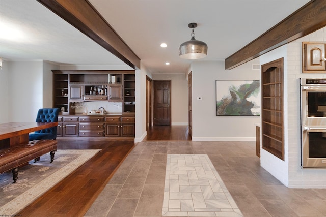 foyer entrance featuring recessed lighting, visible vents, indoor bar, dark tile patterned floors, and beam ceiling