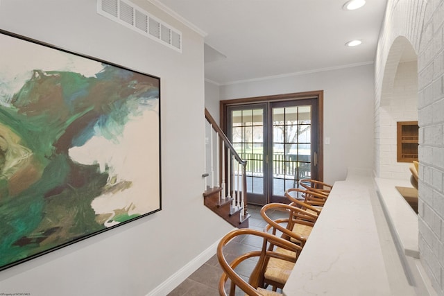 hallway featuring french doors, baseboards, visible vents, crown molding, and dark tile patterned flooring