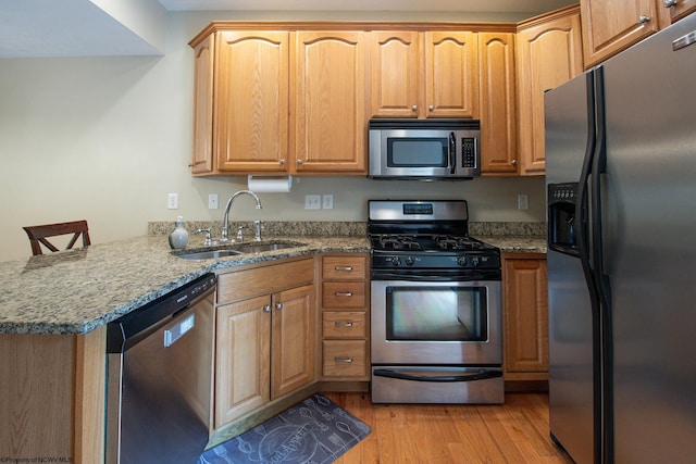 306 Villa View Dr, Morgantown, WV 26505 - kitchen with a peninsula, a sink, stone counters, light wood-style floors, and appliances with stainless steel finishes