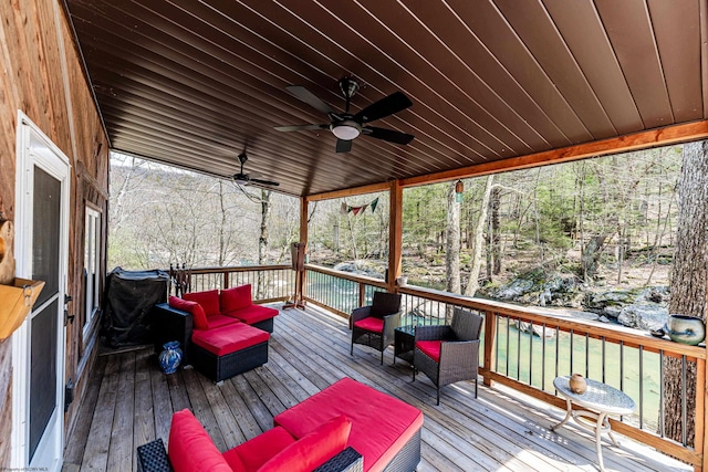 wooden terrace with an outdoor living space and ceiling fan