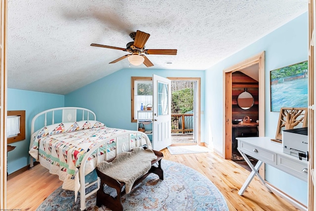 bedroom featuring a ceiling fan, access to exterior, a textured ceiling, and light wood-style floors