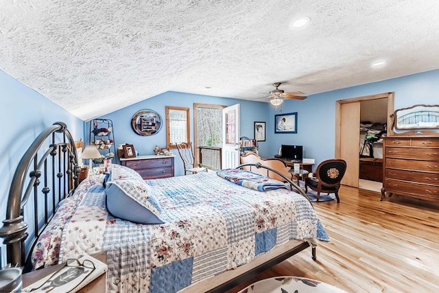 bedroom with a spacious closet, wood finished floors, a textured ceiling, and ceiling fan