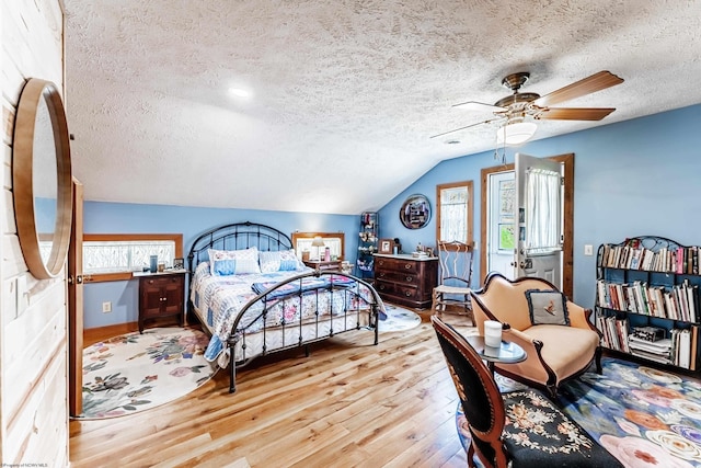 bedroom featuring wood finished floors, a textured ceiling, and multiple windows