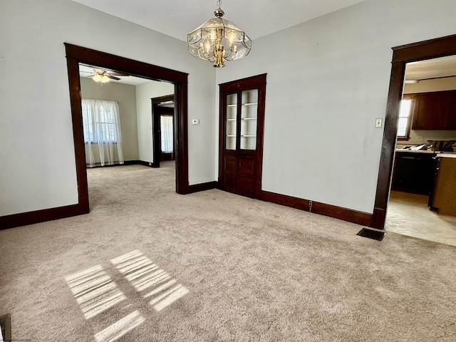 empty room with baseboards, a wealth of natural light, and light colored carpet