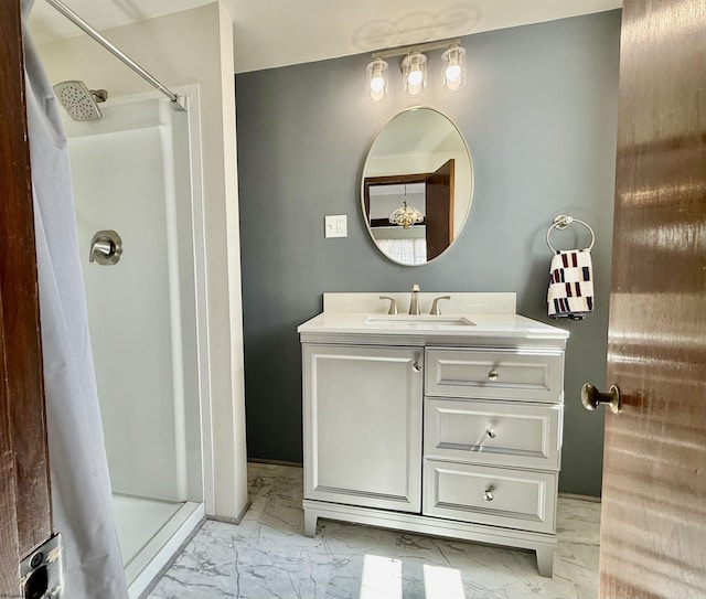 full bath featuring vanity, marble finish floor, and a stall shower