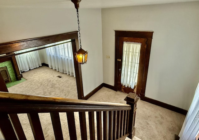 stairway with a fireplace with flush hearth, baseboards, visible vents, and carpet floors